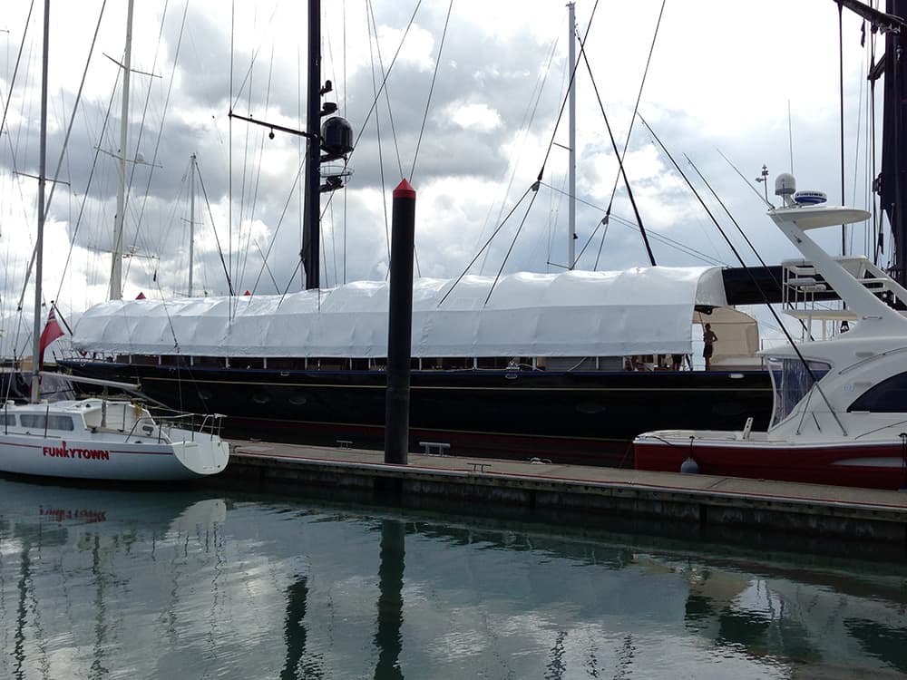 Shrinkwrapped yacht undergoing maintenance at a shipyard in Auckland