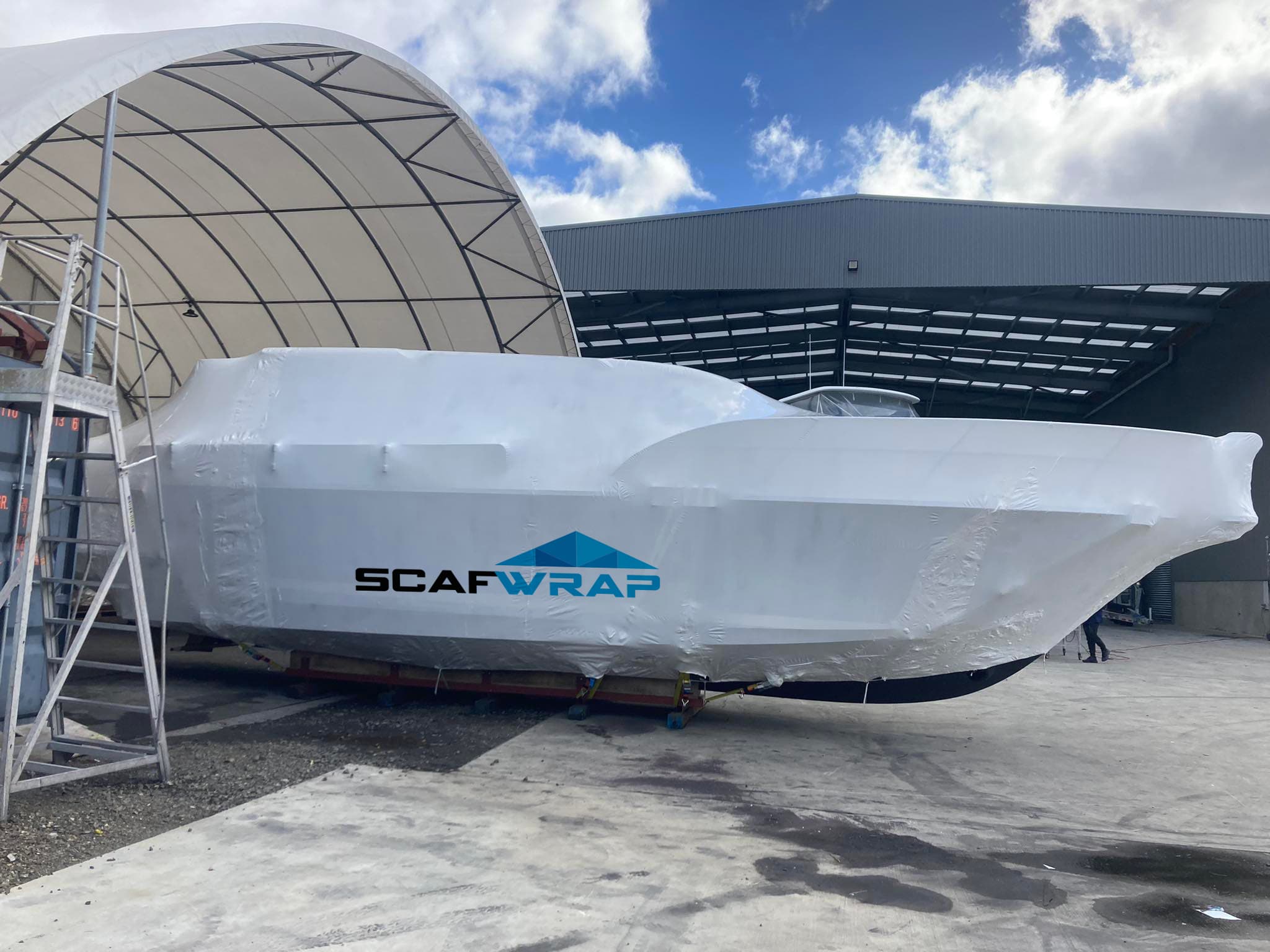 Shrinkwrapped yacht undergoing maintenance at a shipyard in Auckland