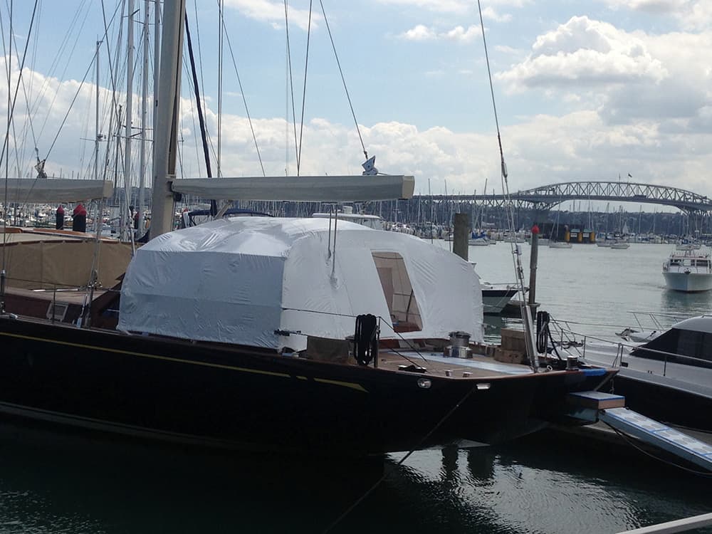 Shrinkwrapped yacht undergoing maintenance at a shipyard in Auckland