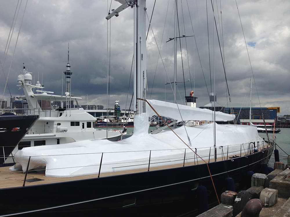 Shrinkwrapped yacht undergoing maintenance at a shipyard in Auckland
