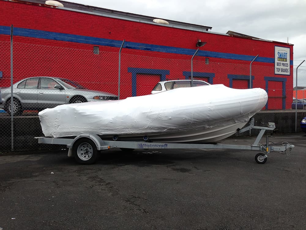 Shrinkwrapped yacht undergoing maintenance at a shipyard in Auckland