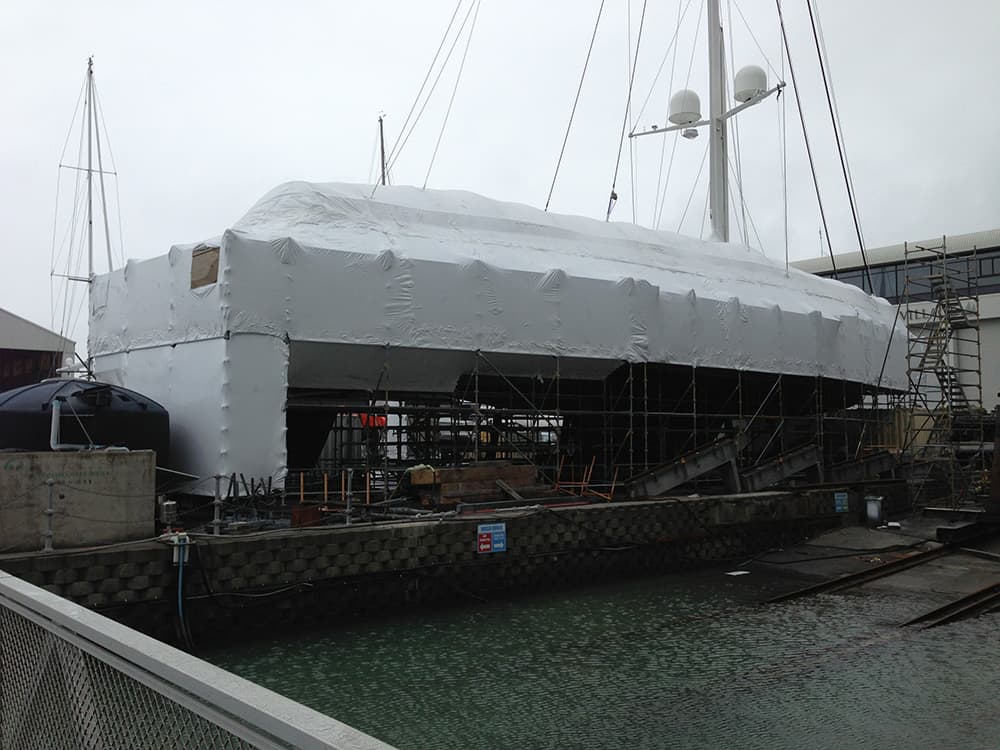 Shrinkwrapped yacht undergoing maintenance at a shipyard in Auckland